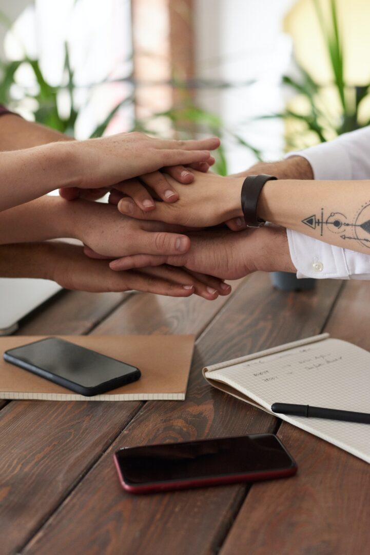 A group of people putting their hands together on a table.